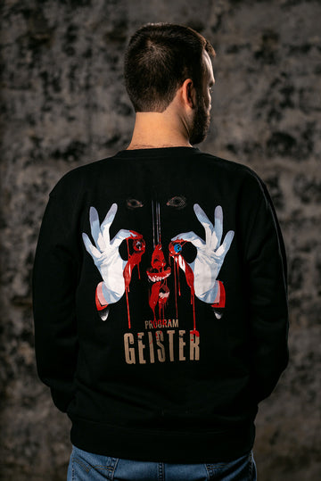 A man viewed from behind wearing a black crewneck sweatshirt with a large graphic print on the back. The graphic features a dripping red skull, white gloved hands forming an 'OK' sign, and the text 'PROGRAM GEISTER'.